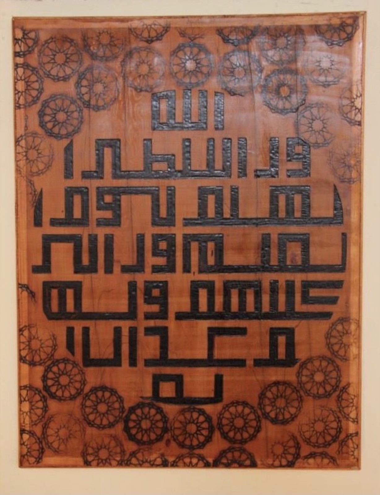 Kufic calligraphy panel above rosette medallions on a warm ground