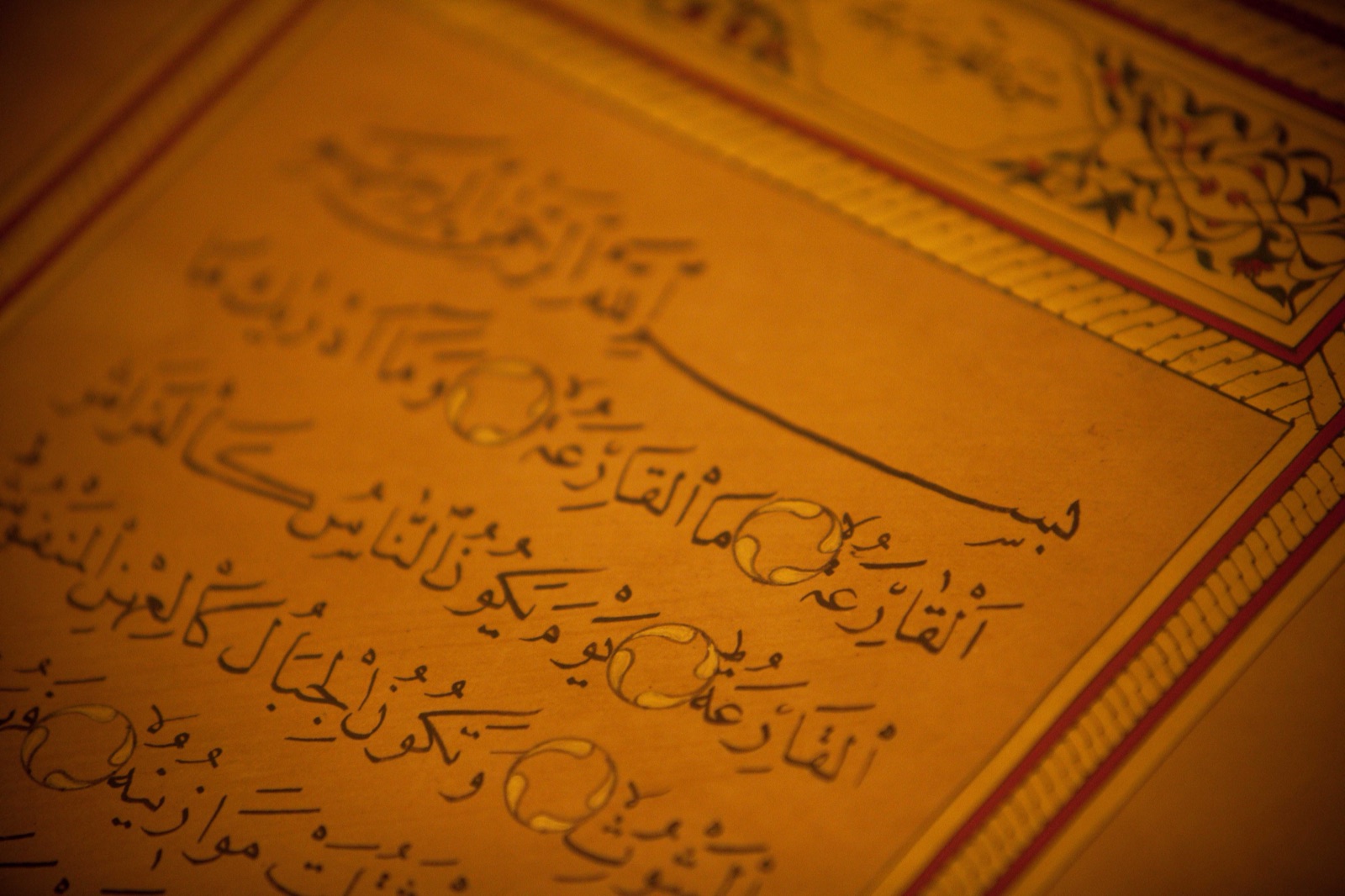 Quranic naskh calligraphy on a gold ground with illuminated border